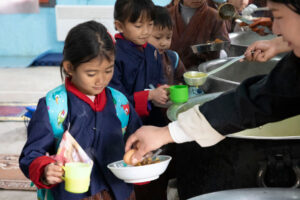 Students at a school in Bhutan receive an egg meal